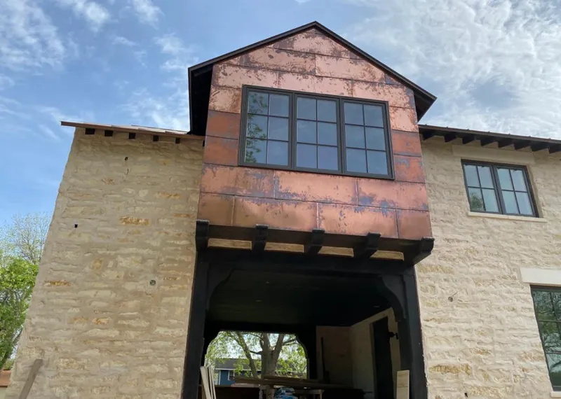 Copper metal panel facade on a stone building for Skylight Installation in Deschutes River Woods